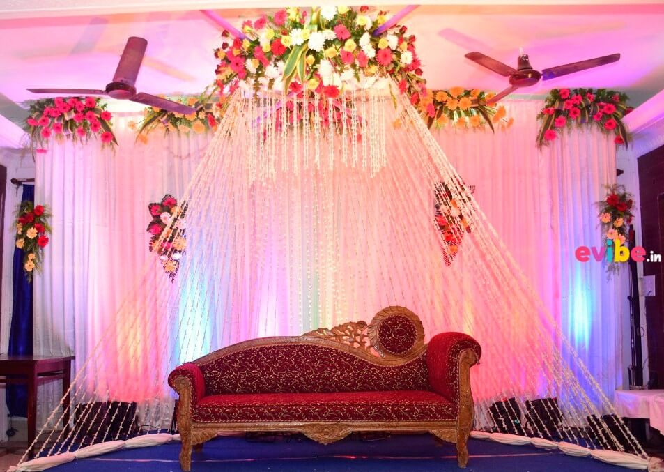 The floral wedding stage is done in hues of red white